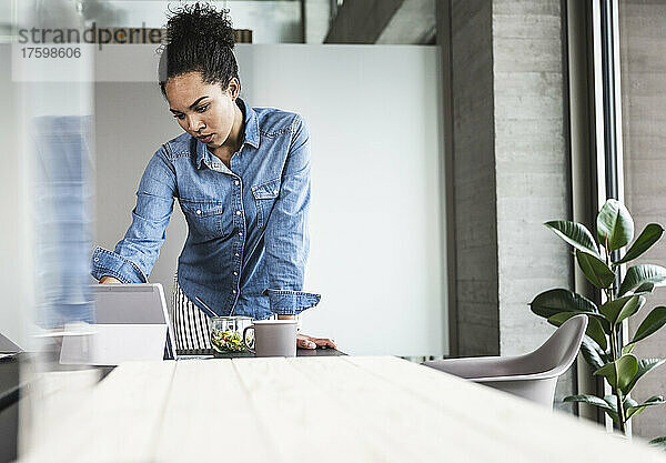 Junge Geschäftsfrau arbeitet am Schreibtisch im Büro am Tablet-Computer