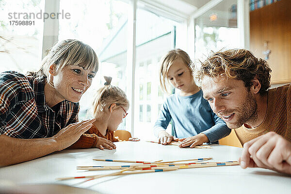 Familie spielt zu Hause gemeinsam Mikado