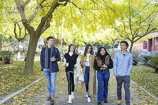 Junge Freunde gehen im College-Park spazieren