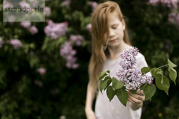 Mädchen mit lila Blumen in der Natur