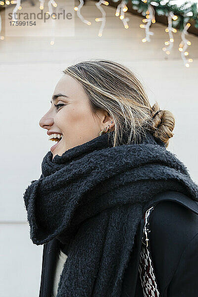 Young blond woman wearing warm clothing laughing