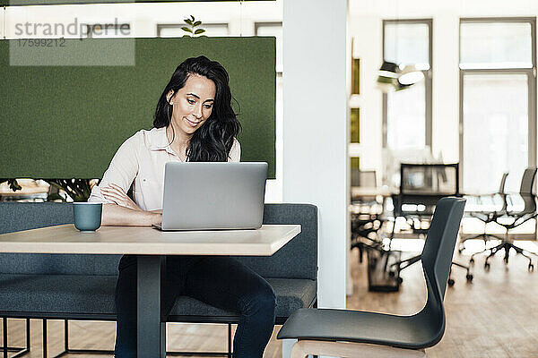 Geschäftsfrau benutzt Laptop am Schreibtisch im Coworking-Büro