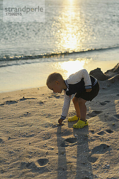 Boy playing with sand on shore at beach  Crimea