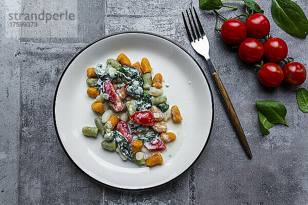 Studio shot of plate of gnocchi with gorgonzola cheese  spinach and tomatoes