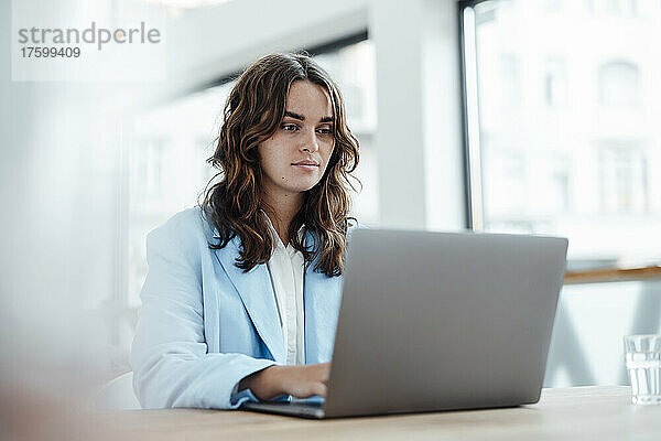 Schöne Geschäftsfrau  die im Büro am Laptop arbeitet