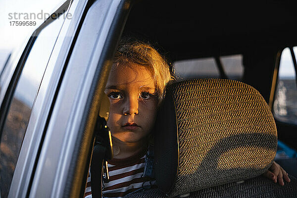 Thoughtful boy traveling in car on road trip