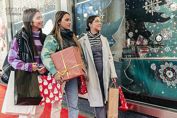 Smiling young women looking at Christmas decoration in store