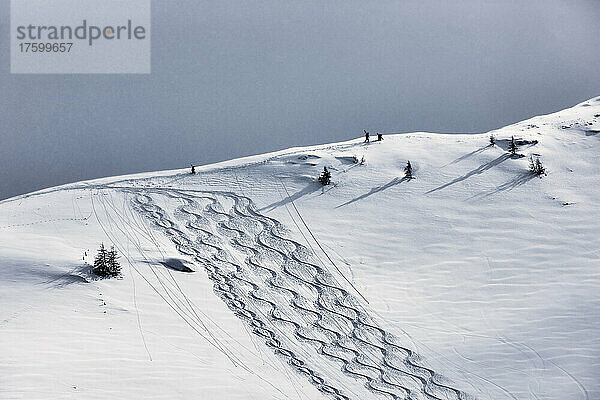 Männer wandern auf schneebedeckten Bergen  Tirol  Österreich