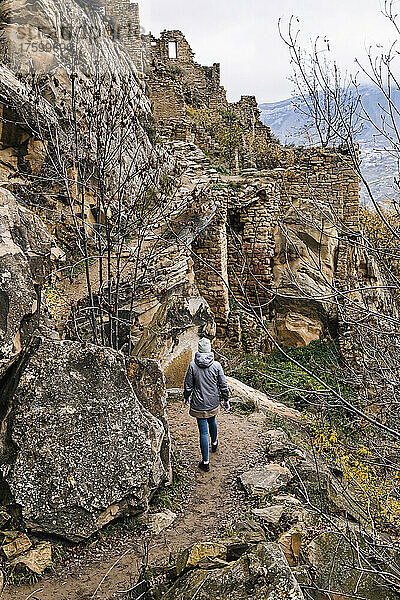 Russland  Dagestan  Gamsutl  Touristin erkundet altes verlassenes Bergdorf im Nordkaukasus