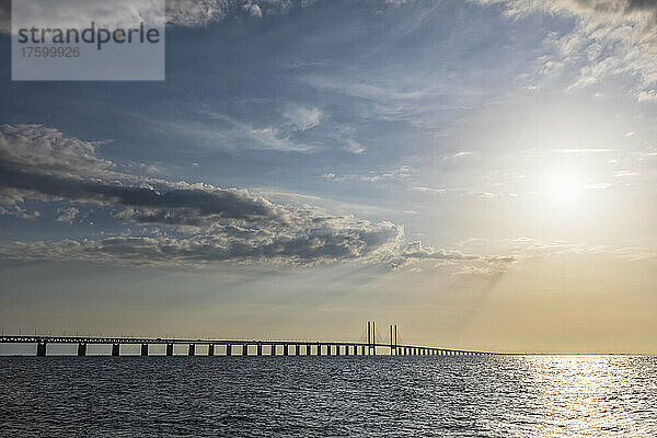 Meerenge bei Sonnenuntergang mit der Silhouette der Öresundbrücke im Hintergrund