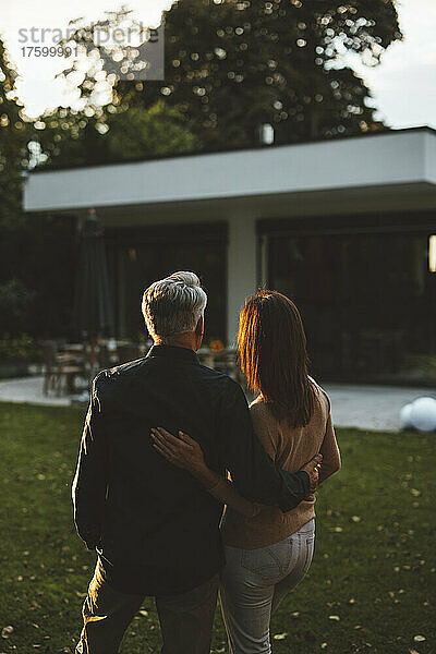 Ein Paar mit Armen steht bei Sonnenuntergang im Hinterhof