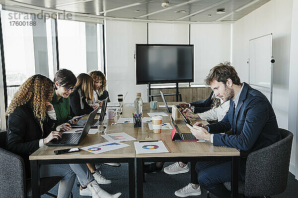 Multiethnische Geschäftskollegen arbeiten am Schreibtisch im Coworking-Büro zusammen