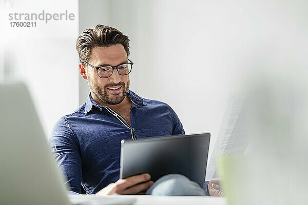 Geschäftsmann mit Brille und Tablet-PC im Büro