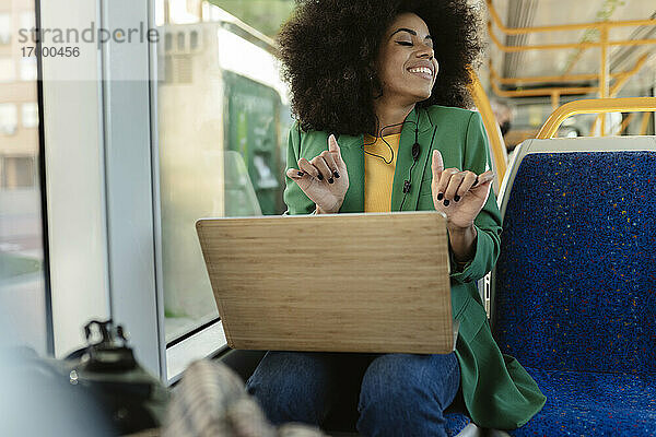 Glücklicher Pendler mit Laptop in der Straßenbahn