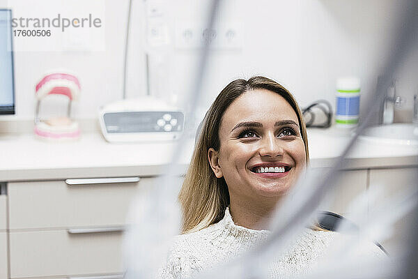 Glückliche junge Frau in der Zahnarztpraxis