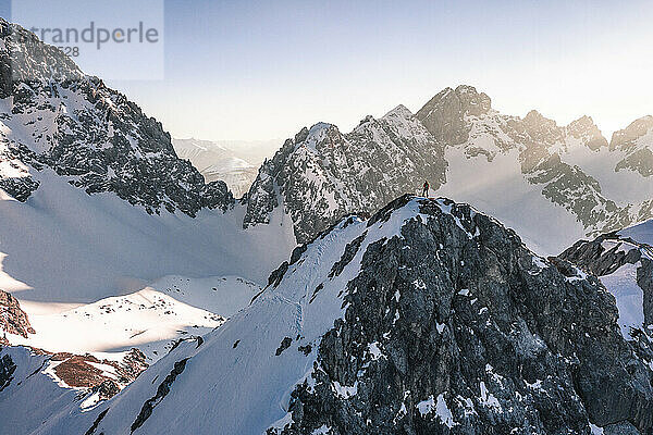 Wanderer steht im Winterurlaub auf einem schneebedeckten Berg  Vorderer Tajakopf  Ehrwald  Tirol  Österreich