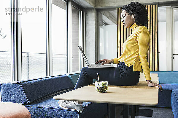 Junge Geschäftsfrau arbeitet am Laptop am Schreibtisch im Büro