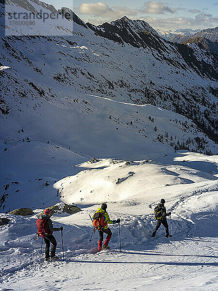 Skibergsteiger folgen einander beim Wandern auf verschneiten Wegen in den Orobischen Alpen im Veltlin  Italien