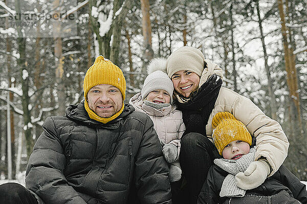 Lächelnder Mann und Frau mit Tochter und Sohn im Winterwald