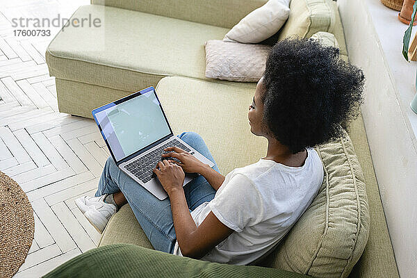 Afro-Geschäftsfrau arbeitet zu Hause im Wohnzimmer am Laptop