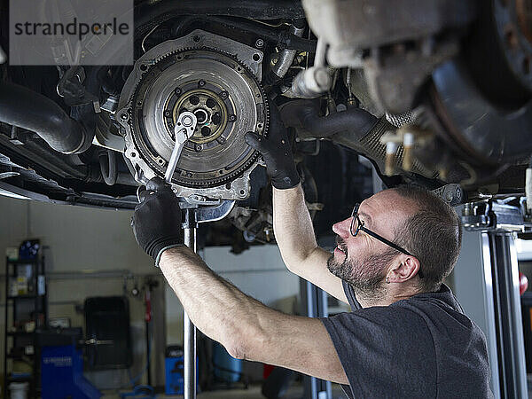 Mechaniker repariert Autorad in Autowerkstatt