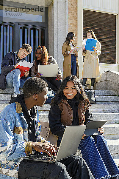 Gemischtrassige College-Studenten studieren auf Stufen auf dem Campus