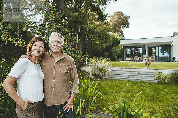 Lächelnde Frau mit braunen Haaren steht neben Mann im Hinterhof