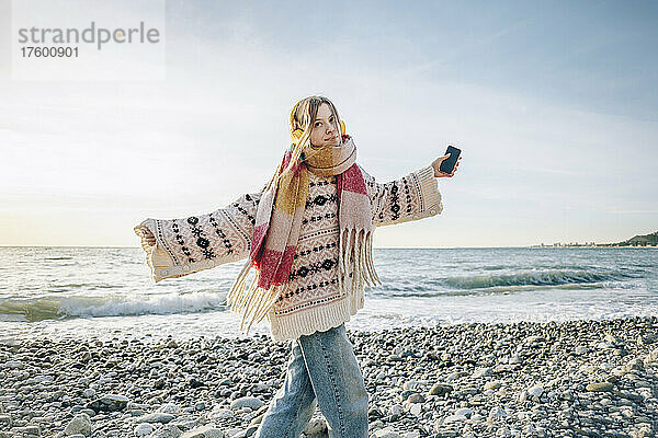 Carefree girl with headphones and smart phone enjoying vacation at beach  Gagra  Abkhazia