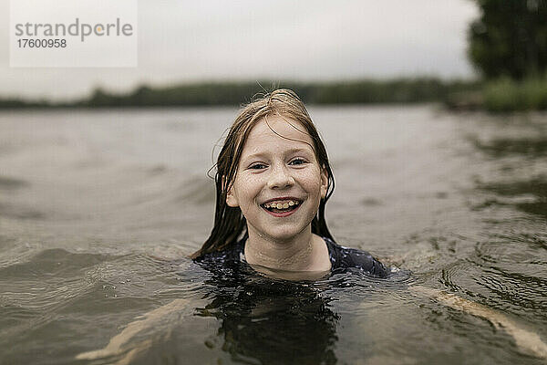 Glückliches Mädchen schwimmt im See