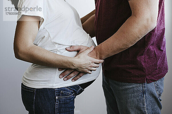 Mann berührt Bauch einer schwangeren Frau zu Hause