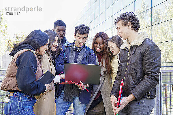 Gemischtrassige Freunde lernen gemeinsam am Laptop auf dem Campus