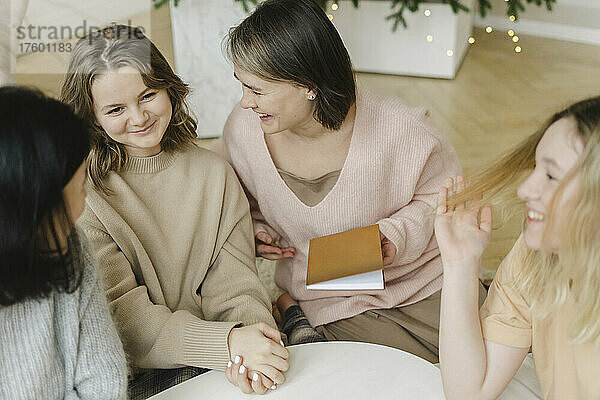 Cheerful women talking with their daughters at home