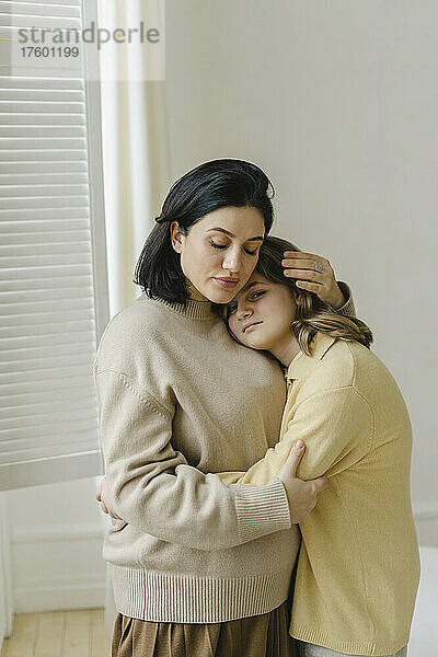Tochter umarmt Mutter zu Hause