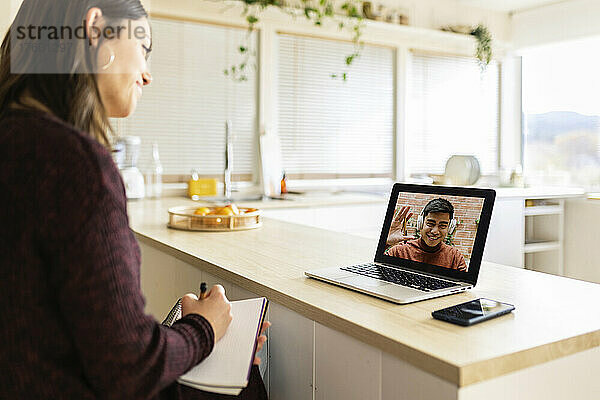 Geschäftsfrau führt zu Hause Videoanruf mit Kollegin am Laptop