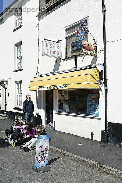 Menschen sitzen vor Pieseas Chippy-Pommesbude. Harwich  Essex  England  Großbritannien  Europa