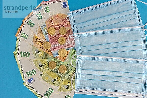 Medizinische Masken und Euro-Banknoten. Finanzkrise aufgrund von Coronavirus-Verlusten  selektiver Fokus
