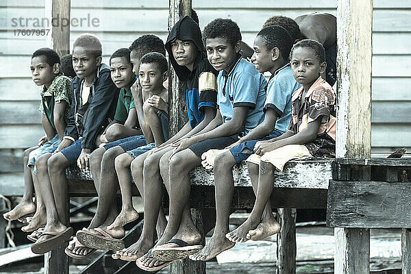 Dorfjungen auf dem Balkon einer Hütte auf der Tuam-Insel der Siassi-Inseln  Papua-Neuguinea; Tuam-Insel  Siassi-Inseln  Papua-Neuguinea