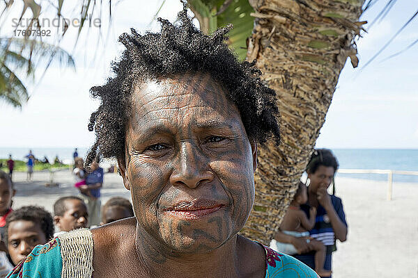 Frau mit Gesichtstattoos am Strand von Buna  Papua-Neuguinea; Provinz Oro  Papua-Neuguinea