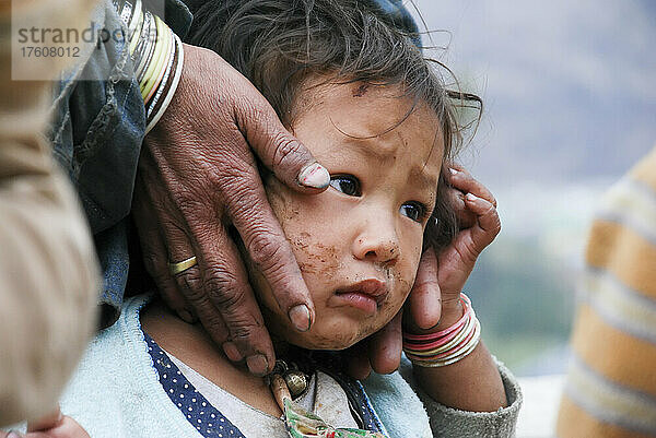Eine Mutter hält den Kopf ihres Kindes in ihren Händen; Punakha  Bhutan