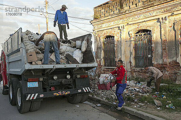 In der Innenstadt von Cienfuegos  Kuba  sammeln mehrere Männer den Müll von der Straße auf und legen ihn in einen Müllwagen; Cienfuegos  Kuba