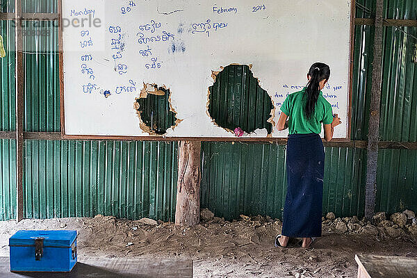 Ein Mädchen schreibt auf Englisch und Khmer an die Tafel in der Green School im Dorf Kampong Tralach  Kambodscha; Bezirk Kampong Tralach  Kambodscha