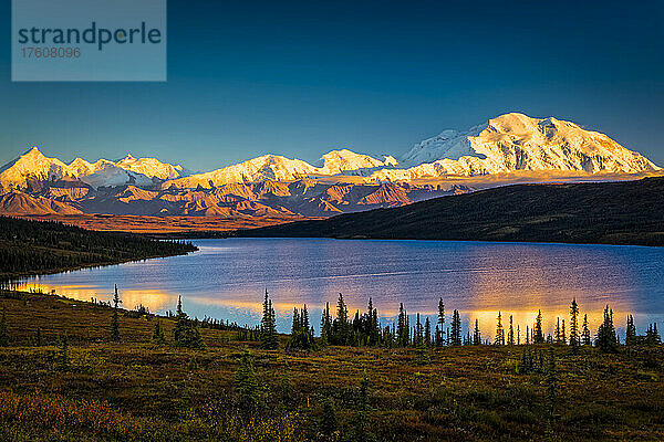 Sonnenuntergangsglühen auf dem Mount Denali (McKinley) spiegelt sich im Wonder Lake mit blauem Himmel  Denali National Park and Preserve im Herbst  Interior Alaska; Alaska  Vereinigte Staaten von Amerika