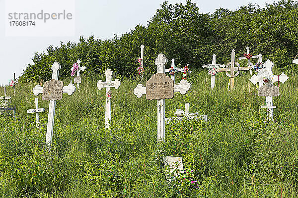 Kreuze markieren den Dorffriedhof auf dem Hügel über Mountain Village im Sommer; Lower Yukon River  Westalaska  Vereinigte Staaten von Amerika