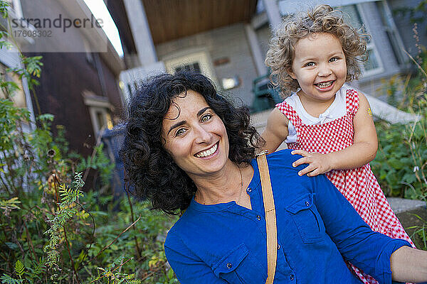 Mutter und kleine Tochter lächeln vor ihrem Haus in die Kamera; Toronto  Ontario  Kanada