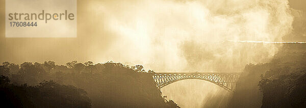 Der Nebel eines Wasserfalls verschlingt eine Brücke.