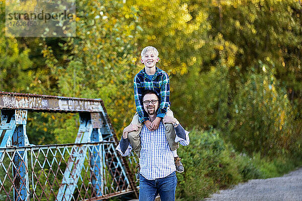 Vater  der seinen Sohn in einem Park im Herbst schultert; Edmonton  Alberta  Kanada