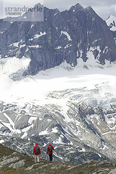 Zwei Wanderer machen eine Pause  um die malerische Aussicht zu genießen; Adamants Mountain Range  British Columbia  Kanada