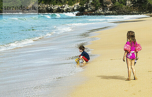 Im Sand spielende Kinder am D. T. Fleming Strand am Rande des Wassers; Kapalua  Maui  Hawaii  Vereinigte Staaten von Amerika