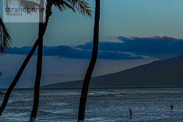 Silhouetten von zwei Stand-up-Paddleboardern an einem Pazifikstrand.