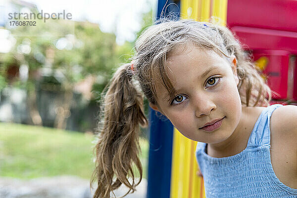 Porträt eines jungen Mädchens im Freien  das auf einem bunten Spielplatzgerät steht; Toronto  Ontario  Kanada